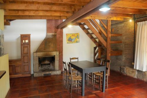 comedor con mesa y chimenea en LA TOMA Complejo de Montaña - Cabañas y Habitaciones en Hosteria en Mina Clavero