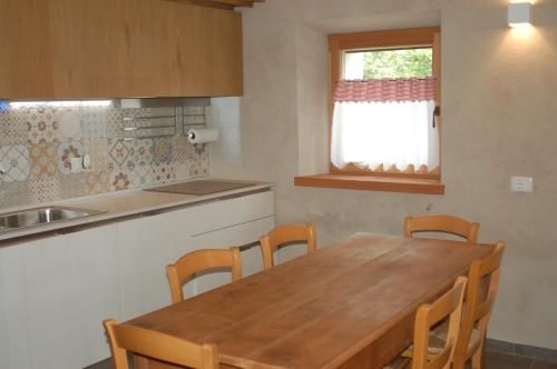 cocina con mesa de madera y sillas de madera en B&B Il Crogiolo en Bosentino