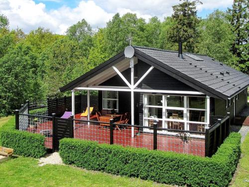 una pequeña casa con techo negro en 6 person holiday home in Hadsund en Odde