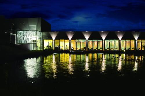 a large building at night with a body of water at Antonie Hotel****superior in Frýdlant