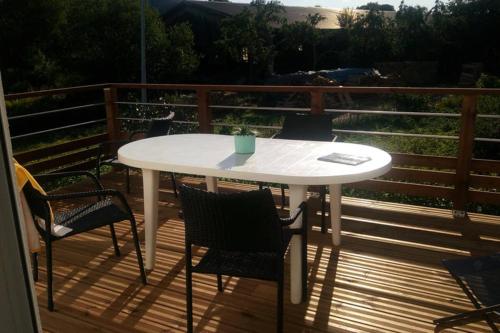une table et des chaises blanches sur une terrasse dans l'établissement Maison indépend. 6 personnes à 10 mn de Gérardmer, à Granges-sur-Vologne