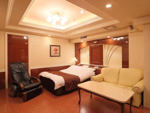 a hotel room with a bed and a couch at Hotel Fine Garden Kuwana in Kawagoe