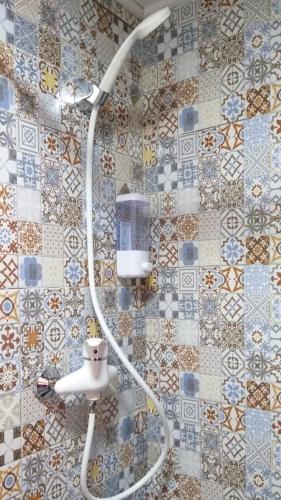 a shower head in a bathroom with a tile wall at Cabañas El Desván in Puente Negro