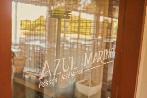 una ventana de cristal con un cartel que diga comercialización azu en Posada Azul Marino, en José Ignacio