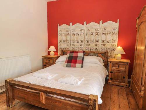 um quarto com uma cama e duas mesas de cabeceira e dois candeeiros em Cooper's Cottage em Pickering