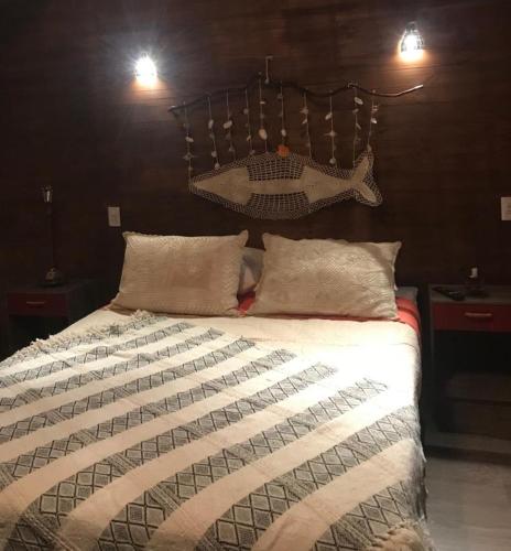 a bedroom with a large bed with a fish headboard at Cabañas El Desván in Puente Negro
