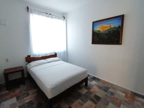 1 dormitorio con cama blanca y ventana en Don Luis Hostal - Sucursal Hidalgo - Tecolutla, en Tecolutla