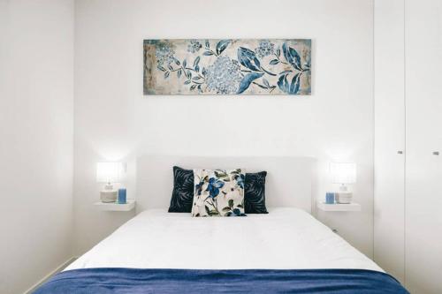 a bedroom with a white bed with two lamps at Salinas Box in Aveiro