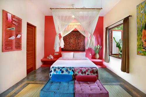 a bedroom with a bed, a dresser and a painting on the wall at PinkCoco Uluwatu - Cool Adults Only in Uluwatu