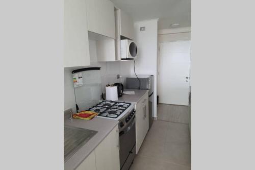 uma cozinha com armários brancos e um forno com placa de fogão em AMUNATEGUI 173 Iquique Centro, ejecutivos em Iquique