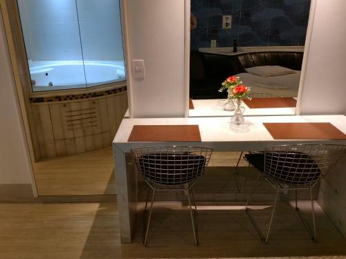 a kitchen with a table and two chairs and a tub at A2 suites - Hotel e Motel in Brasilia
