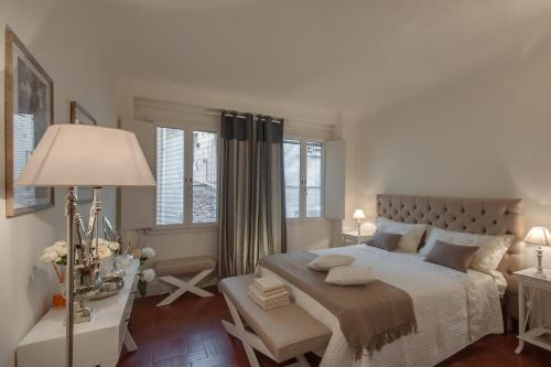 a white bedroom with a large bed and windows at Apartments Florence- Santa Maria Novella in Florence