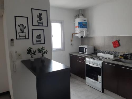 a kitchen with a stove and a microwave at Costanera.VM in Villa María