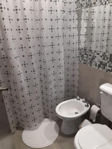 a bathroom with a white toilet and a shower curtain at Costanera.VM in Villa María