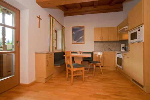 een keuken met een tafel en stoelen in een kamer bij Vorderstockerhof in Sankt Johann in Tirol