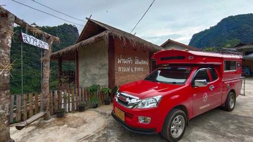 a red truck parked in front of a building at ม่านฟ้า โฮมสเตย์ MaanFah Homestay in Chiang Rai