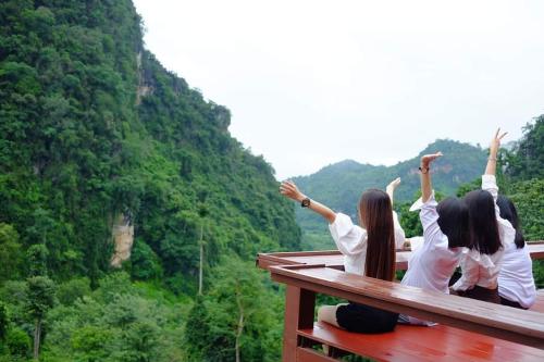 a group of girls sitting on a bench with their hands up at ม่านฟ้า โฮมสเตย์ MaanFah Homestay in Chiang Rai