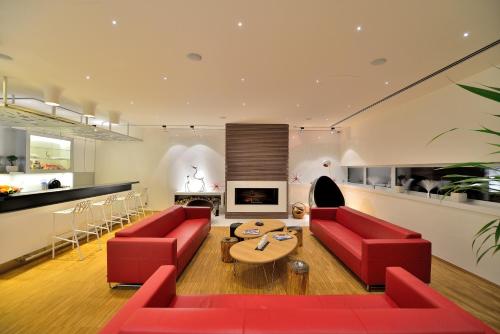 a living room with red couches and a table at Antonie Hotel****superior in Frýdlant