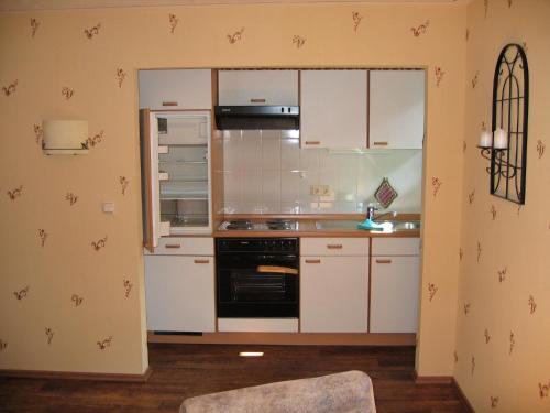 a kitchen with white cabinets and a stove top oven at Sonnenhof-Willingen in Willingen