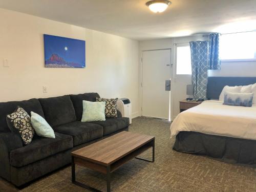un soggiorno con divano e letto di Blue Sage Inn & Suites a Blanding