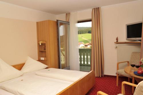a hotel room with a bed and a balcony at Gasthof Reiner in Sankt Englmar