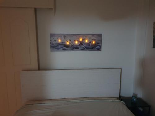 a bedroom with a bed with candles on the wall at The Little House in Voroklini