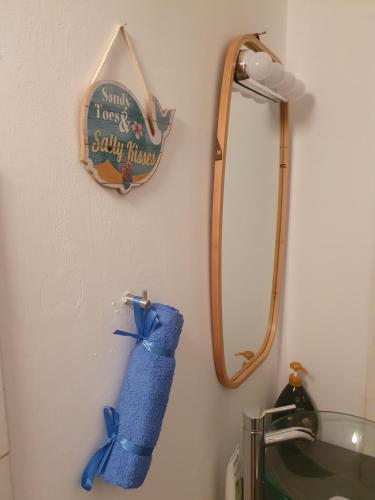 a bathroom with a mirror and a blue towel at The Little House in Voroklini