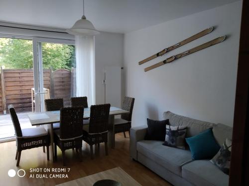 a living room with a couch and a table and chairs at Les mimosas in La Bresse