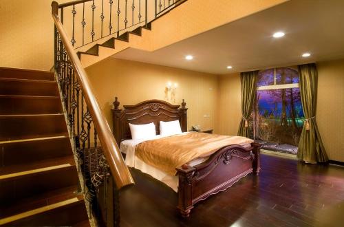 a bedroom with a bed next to a staircase at Huis Ten Bosch in Renai