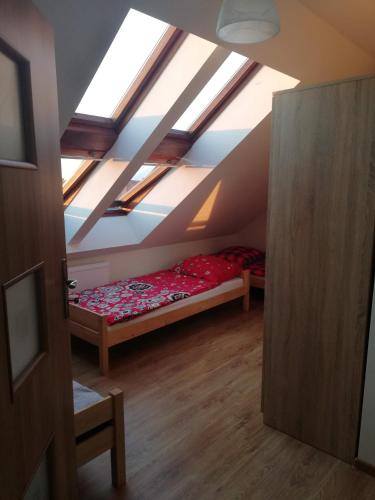 a attic room with a bed and a ceiling with skylights at Apartament Dobrzeń Wielki in Dobrzeń Wielki