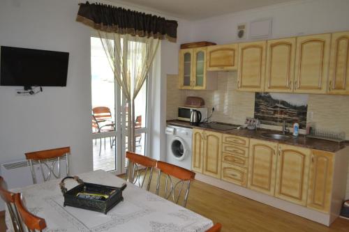 a kitchen with wooden cabinets and a table with a tableablish at Оселя Східниця in Skhidnitsa