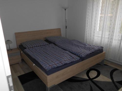 1 dormitorio con cama con marco de madera y ventana en Haus Astrid -Schwerin-Görries - en Klein Rogahn