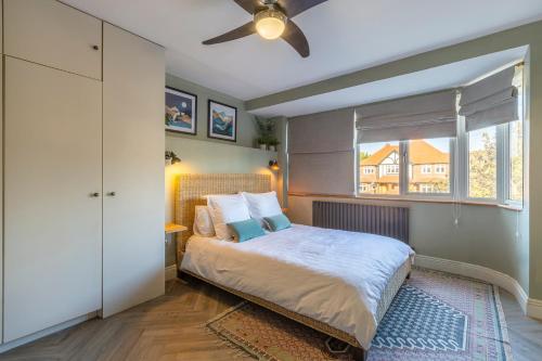 a bedroom with a bed with a ceiling fan at Palm Bay Beach House in Margate