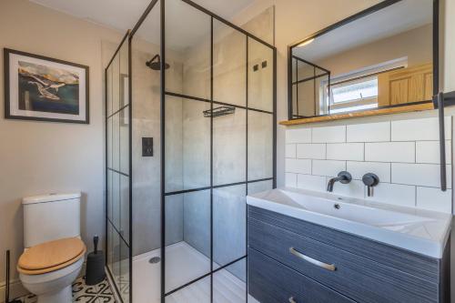 a bathroom with a shower and a sink and a toilet at Palm Bay Beach House in Margate
