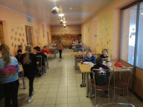 un groupe d'enfants assis à table dans un restaurant dans l'établissement Svečių namai ALDAIVITA, à Ignalina