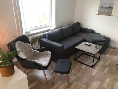 a living room with a couch and two chairs and a table at Seaside VØ in Nørre Vorupør