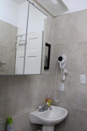 La salle de bains est pourvue d'un lavabo et d'un miroir. dans l'établissement Tropical Garden Cottage Antigua, à Saint Johnʼs