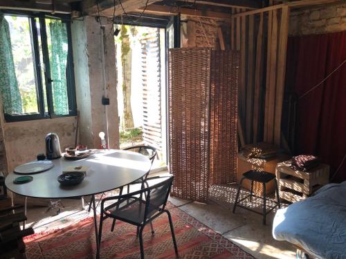 une pièce avec une table, des chaises et un lit dans l'établissement Maison au bord de l’eau, à Annay-sur-Serein
