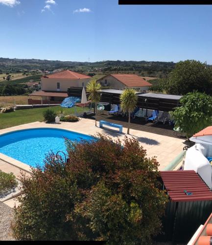 a swimming pool in front of a house at Casa o Futuro in Alcobaça