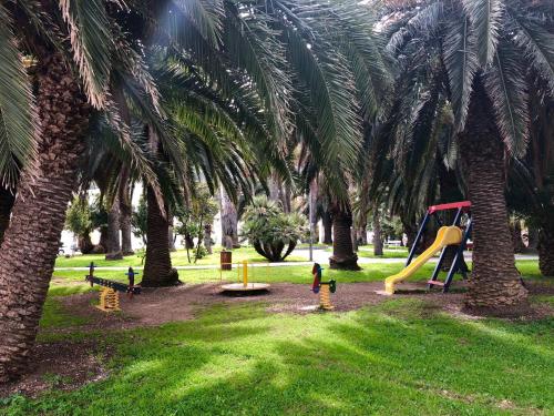 a park with a playground with palm trees at Apartments Karuza Center of old town Vis in Vis