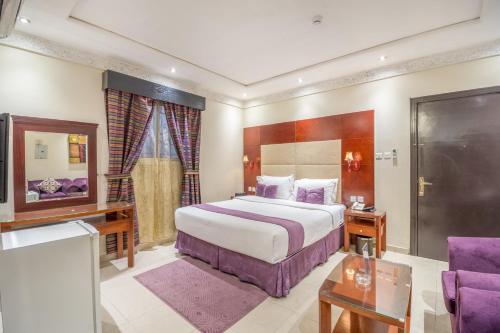 Habitación de hotel con cama grande y sofá en Al Muhaidb Khanshalila en Riad