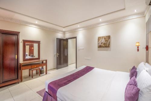 a bedroom with a bed and a desk and a piano at Dar Neyyara Apartments Furnished in Riyadh