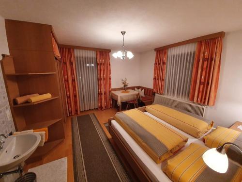 a bedroom with a large bed and a sink at Mascherhof in Obertilliach