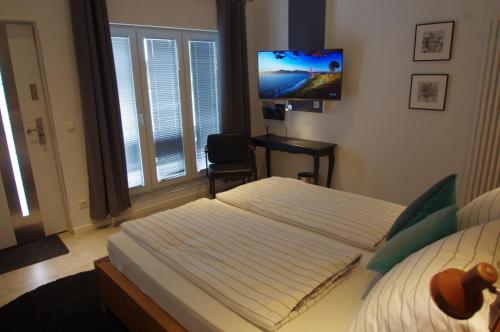 a bedroom with a bed and a desk and a television at CityMotel Ziegenhain in Schwalmstadt