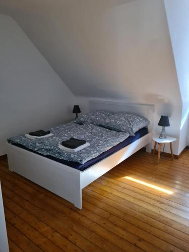 a white bed in a room with a wooden floor at GP Ferienwohnung in Goslar