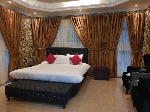 1 dormitorio con cama, sofá y ventanas en White Lodge Guest House, en Islamabad