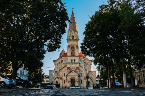 un grand bâtiment avec une tour d'horloge dans une rue dans l'établissement апарт-готель у Кірхи, à Odessa