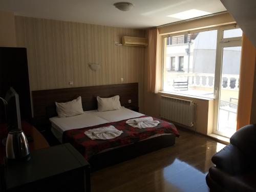 1 dormitorio con 1 cama con 2 toallas en Bon Bon Hotel, en Sofía