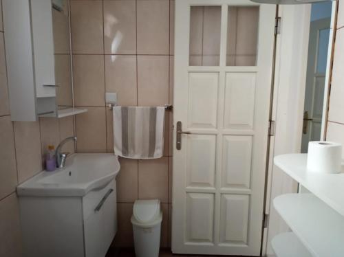a bathroom with a toilet and a sink and a door at Heybe Apart in Kaş