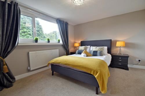 a bedroom with a bed with a yellow blanket on it at Montrose Heights - 4Bed - 4Bath - Central Burnley in Burnley